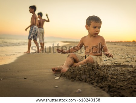 Happy child playing and building in the beach sand