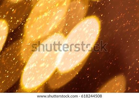 Golden sparkles or glitter lights. Festive gold background. Defocused circles bokeh or particles
