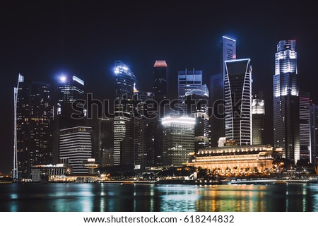 Colorful business district skyline with skyscrapers after sunset at marina bay. Cityscape panoramic night concept with lights reflection, Asia. Singapore city landscape at night. Modern Singapore city