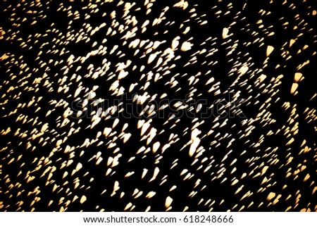 Golden abstract sparkles or glitter lights. Festive gold background. Defocused circles bokeh or particles. Template for design