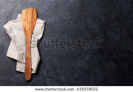 Cooking spoon over towel on stone table. Top view with space for your text