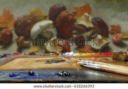 The workplace of the artist, brushes, paints and canvas. Multicolor oil paints on a palette close up.