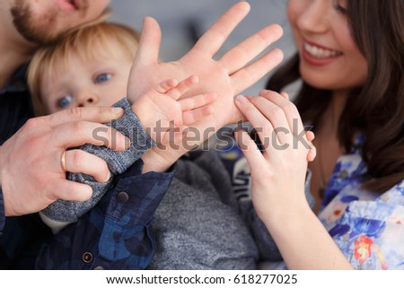 Close up Portrait of happy mother, father and son indoors. Happy birthday, joyful and laughing two years old baby boy. Little kids hands closeup.