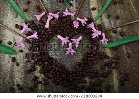 Rustic wooden background with cup of coffee and decorations. Heart shaped chalkboard. Spring flowers Top view