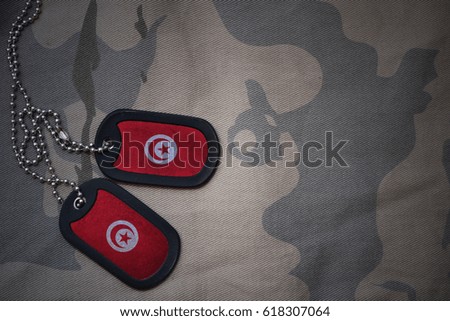 army blank, dog tag with flag of tunisia on the khaki texture background. military concept