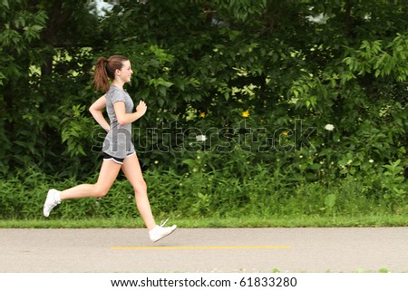 Teenager running on a footpath Royalty-Free Stock Photo #61833280
