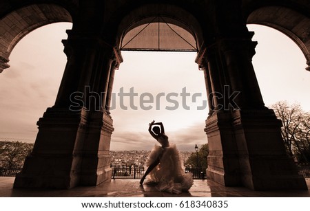 An attractive young woman just married, wearing a stylish white dress, posing and dancing for the wedding pictures, in a charming location in Paris