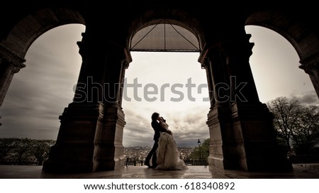 A young couple just married, wearing stylish clothes, posing and dancing for wedding photos, in a charming location in Paris