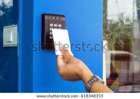 Door access control - young woman holding a key card to lock and unlock door., Keycard touch the security system to access the door