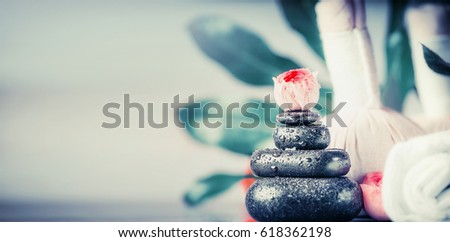 Spa treatment  with stack of black massage stones , flowers and  towels , wellness concept, banner