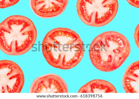 Ripe juicy tomato slices seamless photographic pattern. Isolated on aquamarine background without shadow. Repetitive pattern of tomato pieces on aquamarine underlay. Fresh shiny cuts of love apples