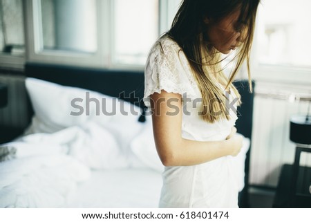 Young woman in the room gets out of bed