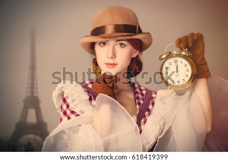 photo of beautiful young woman in vintage dress with alarm clock on Eiffel Tower background