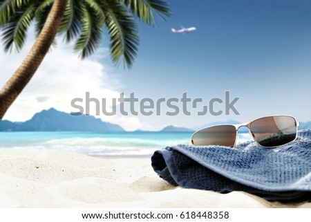 Sunglasses on beach and summer time landscape with palm and plane 