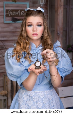 Alice showing open pocket watch in her hand and pointing at it