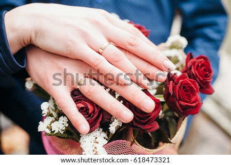 Hands with rings on bouquet