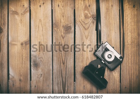 Retro camera over old wood planks background with empty space for design