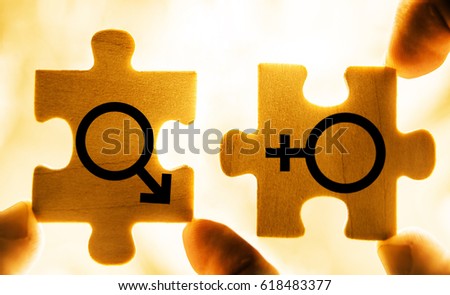 Couple In Love. Mars and Venus wooden symbols together. Hand holding wooden jigsaw puzzles. photo image, isolated on sunset sky background. Sword of Mars. Venus mirror