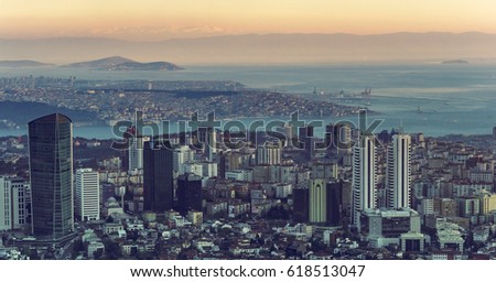 Panorama of Istanbul city - skyscrapers and shoreline of Bosporus, cityscape on sunset. Panoramic view of Istanbul - top view on modern town, seaport and Princes Islands on a horizon.
