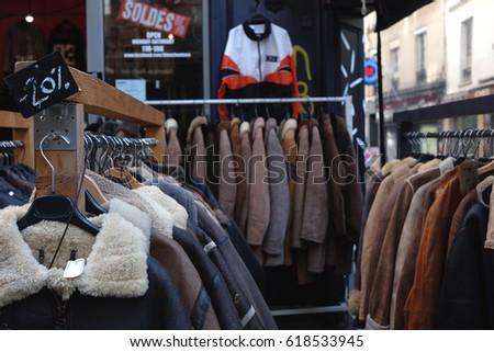 PARIS, FRANCE - February 15 2017: Leather jackets in a second hand thrift store, with "sale" sign in the background (in Franch)