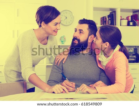 Young father and mother signing realty papers with their daughter 