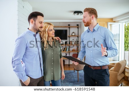 Photo of a young couple counseling with financial adviser at home.