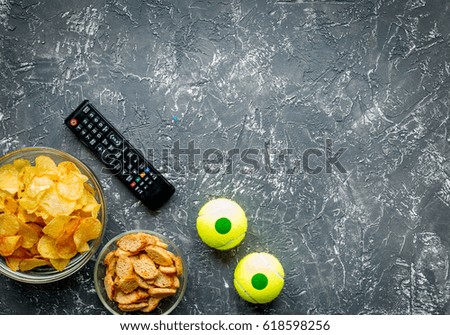 TV control and snacks on dark background top view space for text
