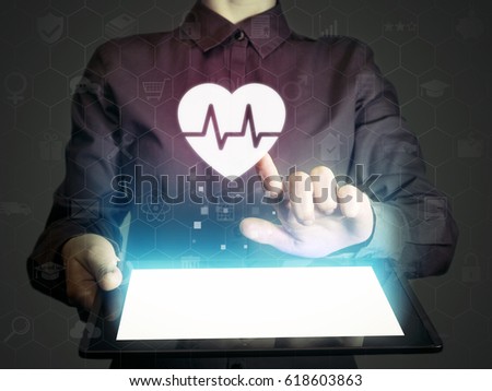 Image of a girl with tablet pc in her hands and heart rate icon. Concept of medical services, diagnosis and treatment.