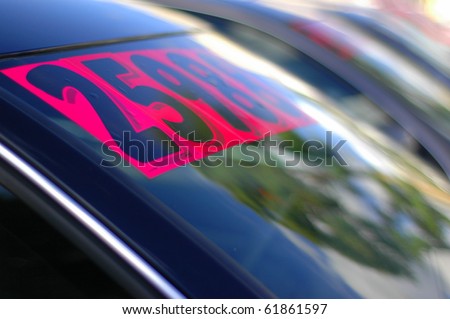 Retail Business Image of Price Stickers on a Row of Used Cars, With Shallow Depth of Focus