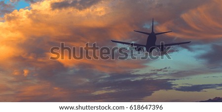 Silhouette of landing airplane at dawn