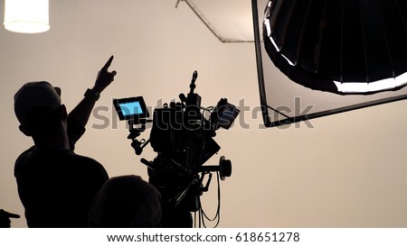 Behind the scene of tv movie video film shooting production crew team and camera lighting set in the big studio. Royalty-Free Stock Photo #618651278