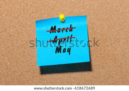 May beginning. Name of month written on blue sticker pinned at noticeboard with crossed out March and April. Spring concept