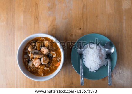 Hot steamed rice with cutlery With shrimp sour soup Thai food spicy. Take a picture from the top corner with a wooden backdrop.