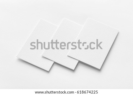 Mockup of three vertical business cards at white textured background.