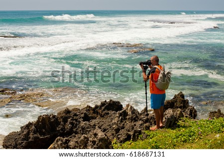 Photographer shoots sea landscape.