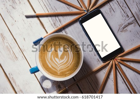 Creative break  - flat white coffee and a smart phone with copy space on a wooden table background.