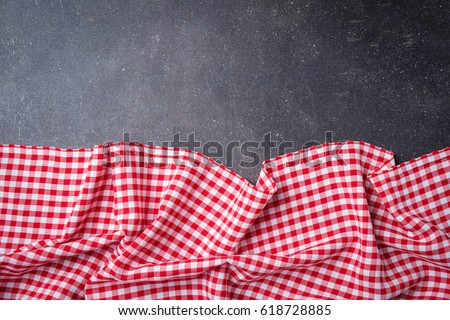Red folded tablecloth on gray stone table. Food background