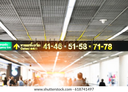 Yellow illuminated sign at airport with gate arrow for departing flights