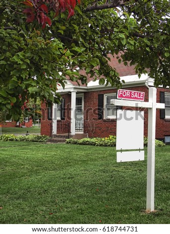 house for sale with for sale sign on lawn