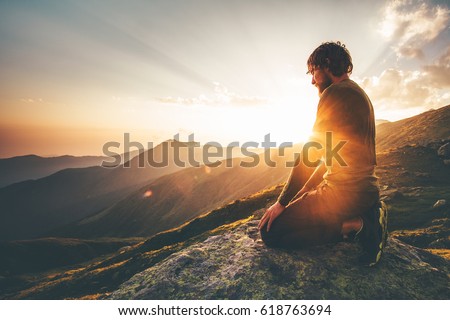 Man relaxing at sunset mountains Travel Lifestyle spiritual awakening emotional meditating concept vacations outdoor harmony with nature landscape Royalty-Free Stock Photo #618763694
