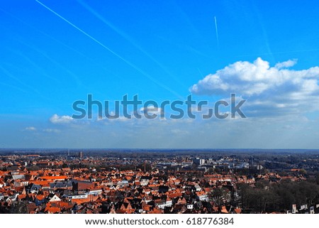 Numerous traces of aircraft in the sky over Bruges, Belgium 