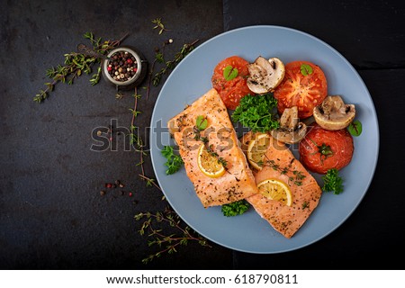 Baked salmon fish fillet with tomatoes, mushrooms and spices. Diet menu. Top view. Flat lay Royalty-Free Stock Photo #618790811