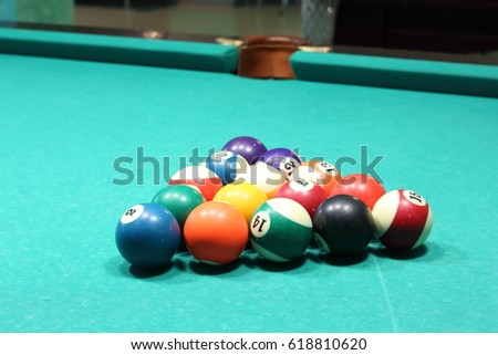 Multicolored billiard balls for snooker on green pool billiard table