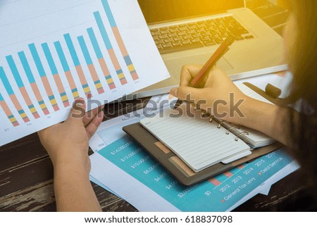 female freelancer hand writing on notebook, thoughtful businessman work on tablet while sitting at wooden table
