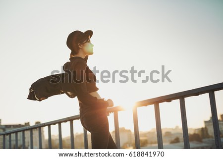 Young stylish sunset urban mood girl. Black clothes and hat. Teen style moment