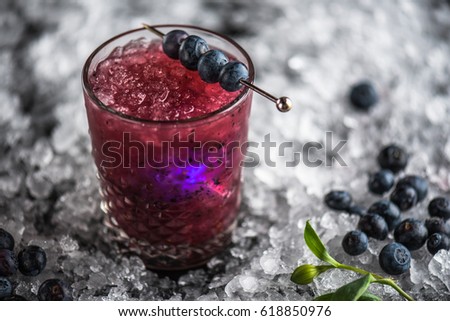 Cocktail in a glass, blueberry and orchid flower on ice against a dark background. A close-up of a drink of fresh lemonade.
 Royalty-Free Stock Photo #618850976