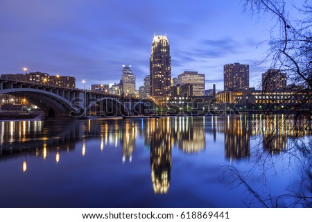Dramatic Clouds and Minneapolis Cityscape Reflect in Mississippi River at Twilight