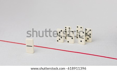 Expelled from the group, unable to cross the red line that separates them. Scene with group of domino. Concept of accusation guilty person, bulling or outcast in the team. Bright background Royalty-Free Stock Photo #618911396