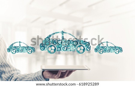 Car icon made of gears and cogwheels on white office background. Mixed media