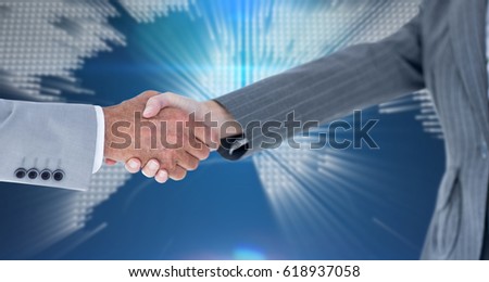 Male and female entrepreneurs shaking hands against glowing world map on black background